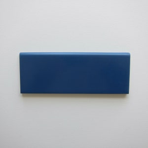May include: A solid blue ceramic tile with a smooth, glossy finish.