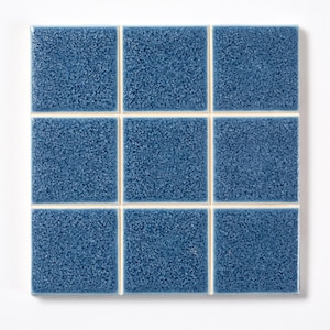 May include: Nine square blue tiles with a textured surface and white grout lines. The tiles are arranged in a 3x3 grid, creating a cohesive square. The tiles have a speckled appearance.