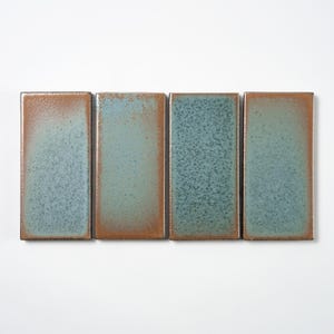 May include: Four rectangular ceramic tiles with a textured, speckled surface. The tiles have a gradient of colors, transitioning from a rusty brown to a teal blue. The edges of the tiles are a dark brown.