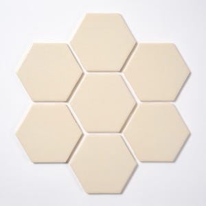 May include: Seven cream-colored, hexagonal tiles arranged in a flower-like pattern. The tiles have a smooth, matte finish and are evenly spaced against a white background. These tiles are suitable for various home decor projects.