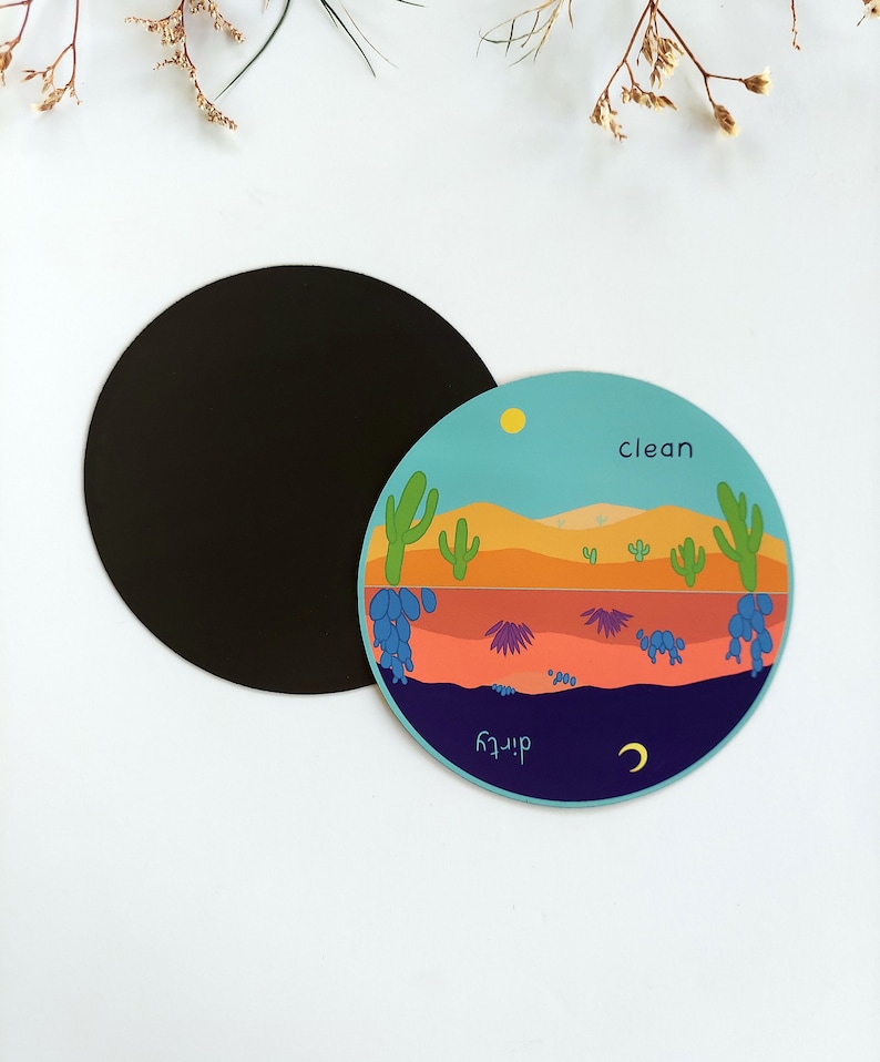 Pu&ograve; includere: Un magnete rotondo blu, arancione e verde con una scena del deserto. Il magnete ha le parole "pulito" e "sporco" scritte su di esso.