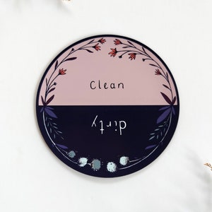 Pu&ograve; includere: Un cartello magnetico rotondo nero e rosa con un design floreale. Il cartello &egrave; diviso a met&agrave;, con "Clean" scritto sulla met&agrave; rosa e "Dirty" scritto sulla met&agrave; nera.