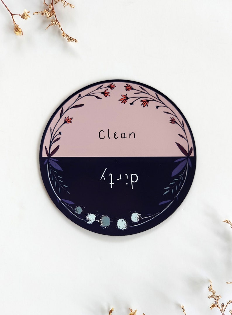 Pu&ograve; includere: Un cartello magnetico rotondo nero e rosa con un design floreale. Il cartello &egrave; diviso a met&agrave;, con "Clean" scritto sulla met&agrave; rosa e "Dirty" scritto sulla met&agrave; nera.