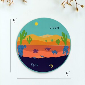 Pu&ograve; includere: Un adesivo rotondo da 12,7 cm di diametro con una scena del deserto. L'adesivo ha un cielo blu con un sole giallo, dune di sabbia arancioni, cactus verdi, fiori viola e blu e un cielo notturno blu scuro con una luna crescente. Le parole "pulito" e "sporco" sono scritte sull'adesivo.