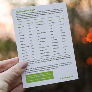 May include: A blue and white cheat sheet with the title "Kruiden cheatsheet" and a table listing various herbs, their minimum temperature, location, water needs, and how long they take to grow. The table includes herbs like basil, rosemary, thyme, oregano, lavender, mint, and more.