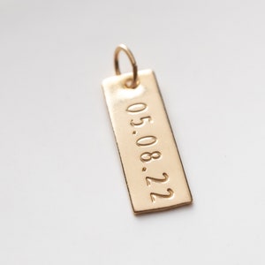 close up of the rectangle charm with the date.