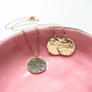 The larger disc necklace is shown with matching hammered dangle earrings.