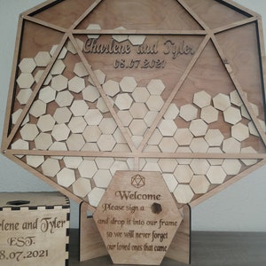 May include: Wooden wedding guest book alternative with a geometric design. The sign features the names "Charlene and Tyler" and the date "08.07.2021". Includes a box and a welcome sign with instructions for guests.