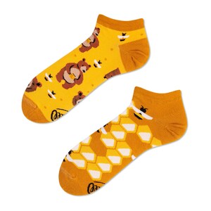 May include: A pair of yellow ankle socks with a pattern of honeycombs, bees, and bears.