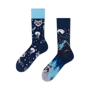 May include: A pair of blue and white socks featuring a wolf howling at the moon design. The socks have a blue background with white accents and a wolf howling at the moon.