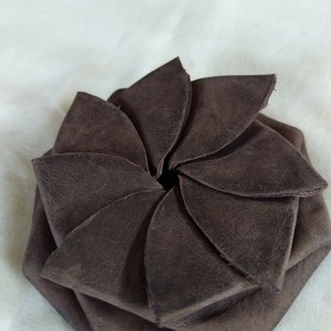 Monedero de cuero envejecido marrón chocolate con acabado mate, estilo vintage, con forma de pétalo y molinete