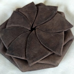 May include: A brown leather coin purse folded into a flower shape.