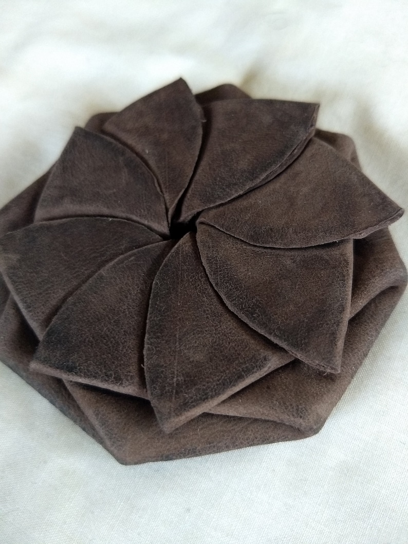 May include: A brown leather coin purse folded into a flower shape.