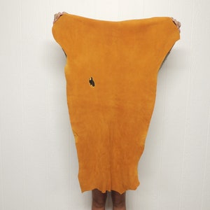 May include: A large piece of orange leather with a small hole in the centre.