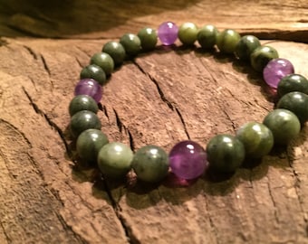 May include: A green and purple beaded bracelet with alternating green and purple beads. The bracelet is made of natural stones.