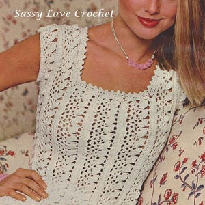 May include: A white crochet top with a square neckline and sleeveless design. The top features a delicate, lacy pattern and is worn by a model with long blonde hair. The text "Sassy Love Crochet" is visible in the image.