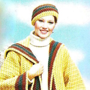 May include: A yellow crocheted cardigan with brown, green, and red stripes. The cardigan has a hood and pockets. The model is wearing a white turtleneck sweater and a striped crocheted hat.
