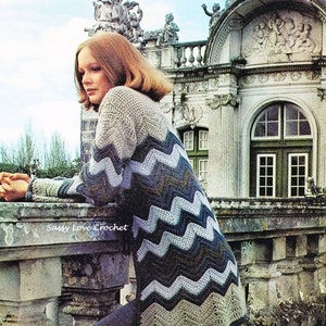 May include: A vintage crochet sweater with a chevron pattern in shades of gray, blue, and white. The sweater is paired with dark gray pants. The image includes the text "Sassy Love Crochet".