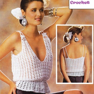 May include: A white crochet top with a V-neck and a fitted waist. The top is shown on a model wearing a black skirt. The text "Sassy Love Crochet" is visible in the top right corner of the image.