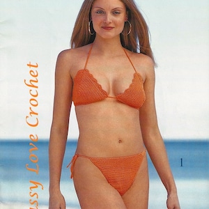 Puede incluir: Un top y una parte inferior de bikini de ganchillo en color naranja brillante. El top del bikini tiene forma triangular con un borde festoneado. La parte inferior del bikini tiene un corte de talle bajo con lazos en los lados.