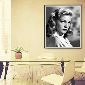 Op de afbeelding: Zwart-wit portretfoto van een vrouw met kort, golvend haar. Ze draagt een witte trui met een hoge hals en kijkt naar de zijkant.