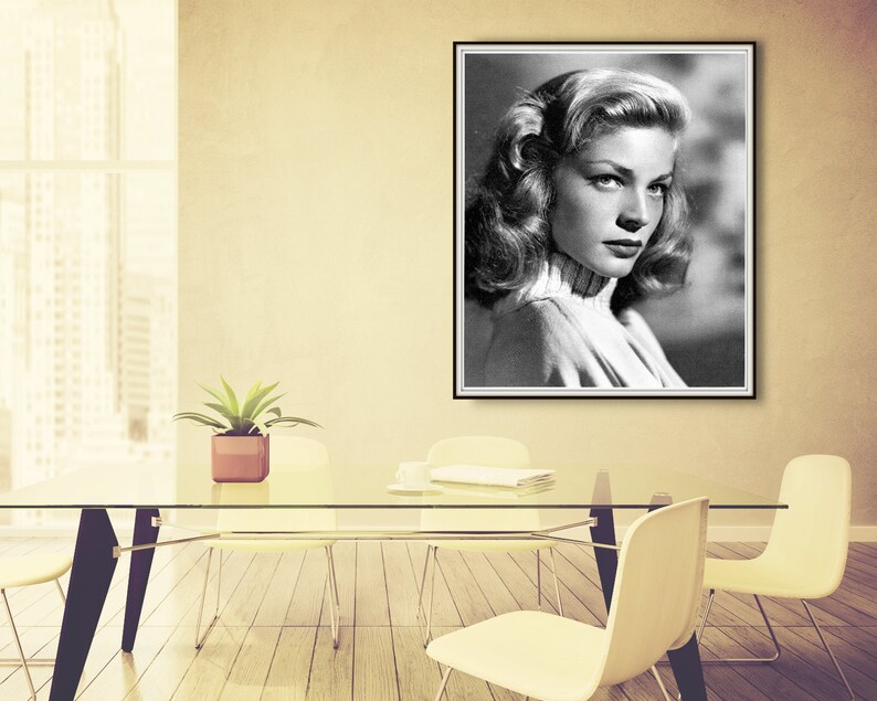Op de afbeelding: Zwart-wit portretfoto van een vrouw met kort, golvend haar. Ze draagt een witte trui met een hoge hals en kijkt naar de zijkant.