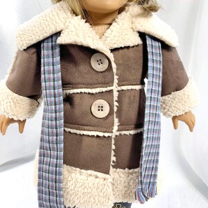 May include: A brown faux fur coat with a white sherpa collar and trim. The coat has a plaid scarf and three large brown buttons.