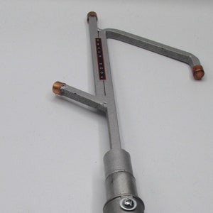 May include: A silver reach hook with a gray adjustable handle and copper tips. The hook is labeled "REACH HOOK".