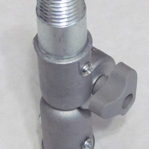May include: A silver metal adjustable pipe fitting with a threaded end and a knob for tightening. The fitting is designed to connect two pipes together at an angle.