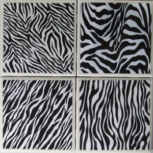 May include: Set of four black and white zebra print ceramic coasters. The coasters are square shaped and have a white border.