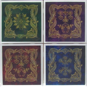 May include: Set of four square coasters with a gold lace design on a green, purple, red, and blue background.
