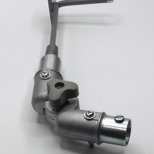 May include: A silver metal adjustable arm with a flat plate on one end and a threaded connector on the other. The arm has a knob for adjusting the angle.