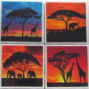 Könnte beinhalten: Set aus vier quadratischen Untersetzern aus Keramik mit einer Silhouette eines afrikanischen Savannen-Sonnenuntergangs mit Giraffen und Elefanten. Die Untersetzer sind weiß mit glänzender Oberfläche.