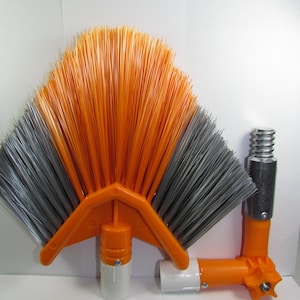 Peut inclure: Brosse inclinée orange et grise avec un manche blanc et une perche télescopique. La brosse a une forme en éventail avec des poils des deux côtés.