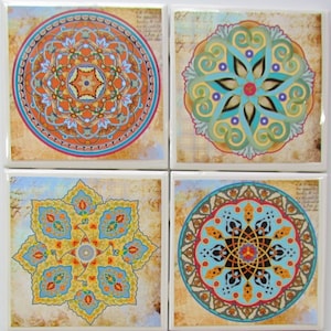 May include: Set of four ceramic coasters featuring colorful mandala designs. Each coaster has a different intricate pattern with shades of blue, orange, yellow, and green.