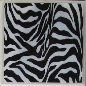May include: Black and white zebra print coaster. The coaster is made of a hard, durable material and is perfect for protecting your furniture from spills and scratches.