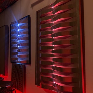 May include: Two rectangular sound panels with a wave-like design. The panel on the left has blue lights, and the panel on the right has red lights.