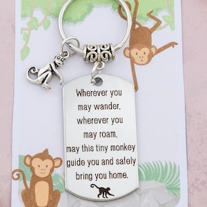 May include: A silver keyring with a small monkey charm. The keyring has a tag with the inscription: "Wherever you may wander, wherever you may roam, may this tiny monkey guide you and safely bring you home."