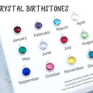 May include: A set of 12 crystal birthstones, each representing a different month of the year. The stones are displayed on a white surface with the corresponding month name written below each stone. The text "CRYSTAL BIRTHSTONES" is at the top of the image. The text "Choose the birth month required or just pick your favorite color!" is at the bottom of the image.
