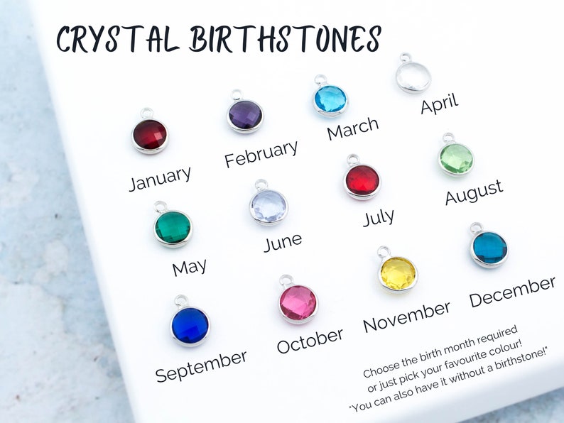 May include: A set of 12 crystal birthstones, each representing a different month of the year. The stones are displayed on a white surface with the corresponding month name written below each stone. The text "CRYSTAL BIRTHSTONES" is at the top of the image. The text "Choose the birth month required or just pick your favorite color!" is at the bottom of the image.