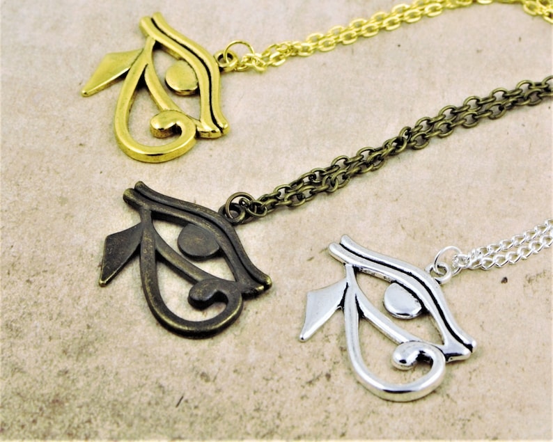 May include: Three necklaces with the Eye of Horus pendant in gold, bronze, and silver.