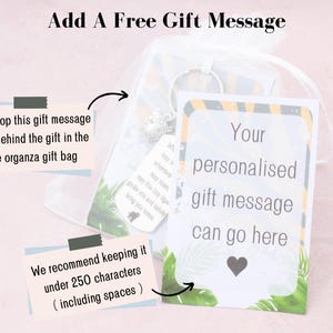 Może przedstawiać: Biała organzaowa torebka prezentowa z kartą, na kt&oacute;rej napisano "We'll pop this gift message card behind the gift in the free organza gift bag". Karta znajduje się obok białej karty z zielono-ż&oacute;łtą kwiatową ramką. Na karcie napisano "Your personalised gift message can go here".