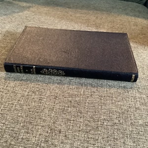 May include: A dark blue hardcover book with gold lettering on the spine. The title is "Essays and Poems" by F.W. Robertson.