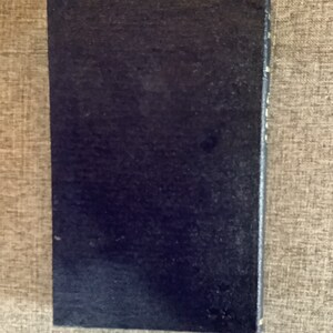 May include: A dark blue hardcover book with a plain cover.