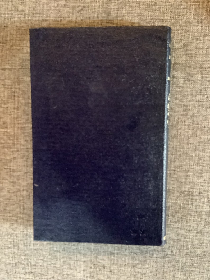 May include: A dark blue hardcover book with a plain cover.