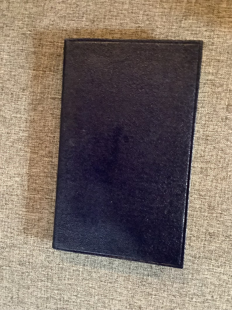 May include: A dark blue, textured, rectangular notebook.