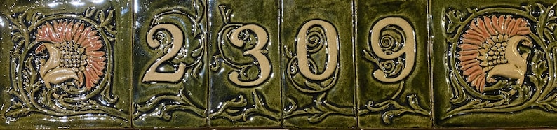 May include: A set of five ceramic tiles with a green background and white numbers. The numbers are 2309. Each tile has a floral design around the number.