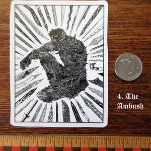 K&ouml;nnte beinhalten: Schwarz-wei&szlig;er Aufkleber mit einer detaillierten Illustration einer Person, die von stilisierten Messern umgeben ist. Der Text "4. The Ambush" ist sichtbar. Eine kanadische M&uuml;nze liegt neben dem Aufkleber.