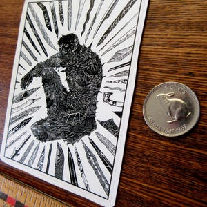 K&ouml;nnte beinhalten: Schwarz-Wei&szlig;-Kunstdruck mit einer sitzenden Figur, umgeben von stilisierten Klingen. Die Figur ist aufwendig mit Mustern detailliert. Eine kanadische 5-Cent-M&uuml;nze befindet sich neben dem Druck. Ein Holzlineal ist im Vordergrund.