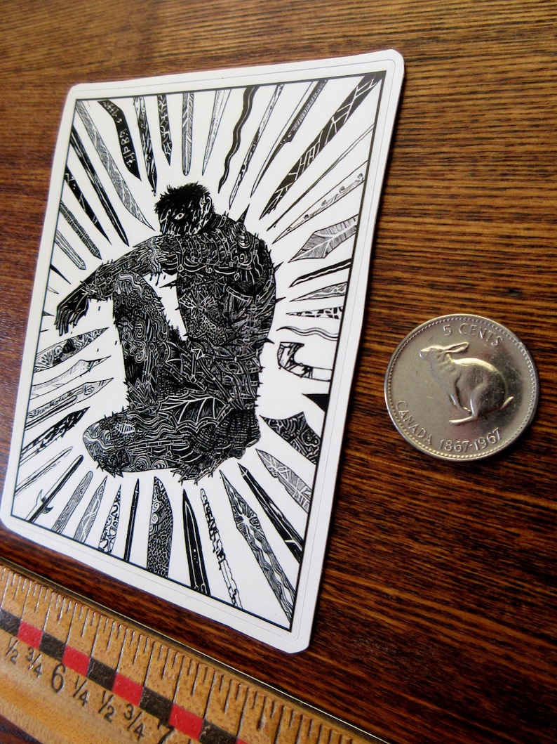 K&ouml;nnte beinhalten: Schwarz-Wei&szlig;-Kunstdruck mit einer sitzenden Figur, umgeben von stilisierten Klingen. Die Figur ist aufwendig mit Mustern detailliert. Eine kanadische 5-Cent-M&uuml;nze befindet sich neben dem Druck. Ein Holzlineal ist im Vordergrund.